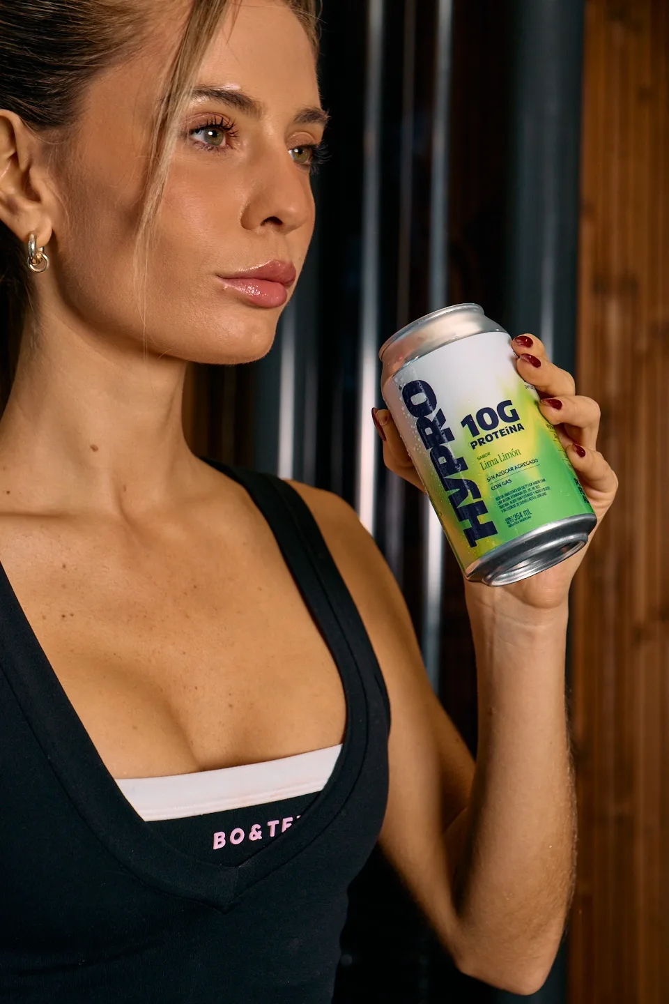 Mujer sosteniendo una lata de HYPRO cerca del rostro