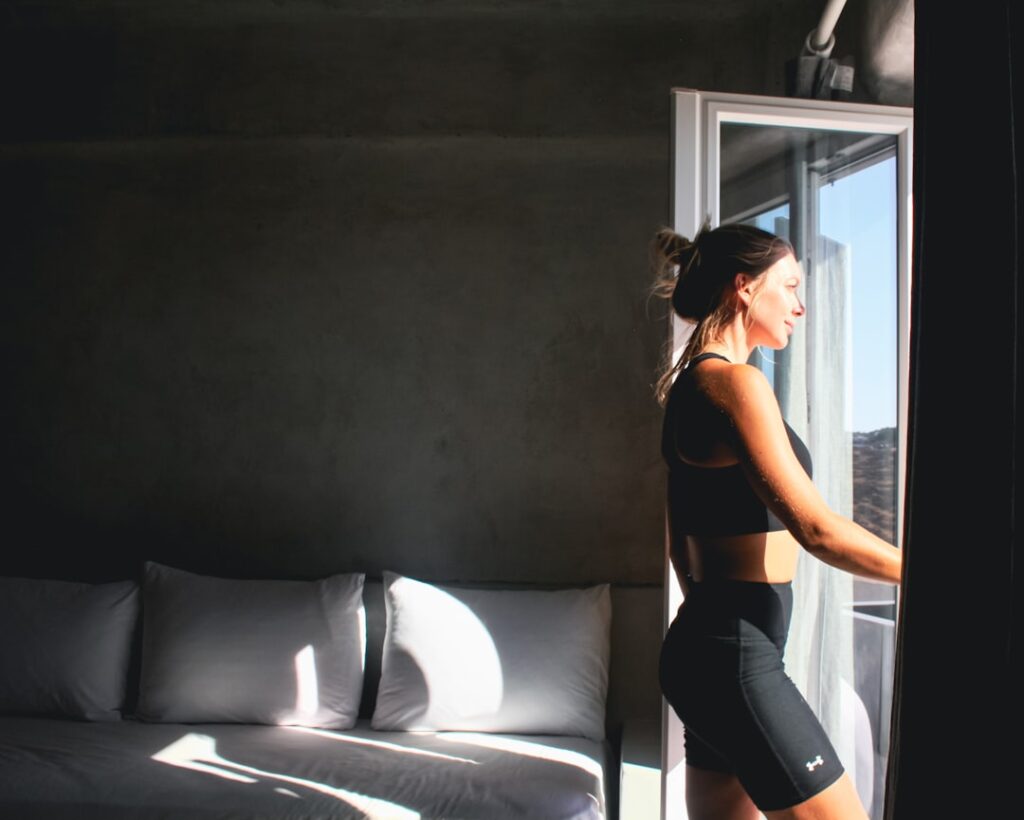 woman adjusting a waist pack before workout in a modern gym, natural morning light
